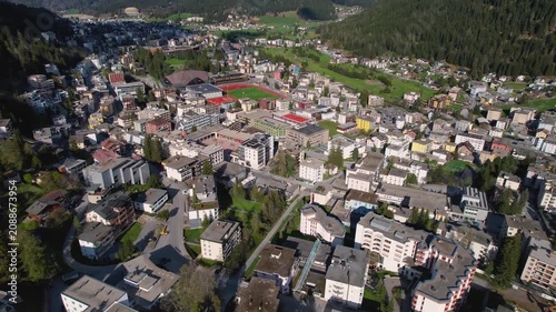 Aerial panoramic view above the downtown around the city Davos in Switzerland on a sunny summer afternoon. 