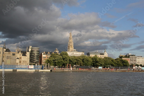 the skyline of antwerp with the quay of the linkeroever and the tower of the church and apartment buildings and office buildings along the western scheldt