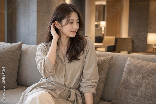 ラウンジのソファで髪を耳にかける女性