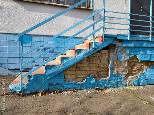 Foto The school facade is deteriorating with missing tiles and broken steps