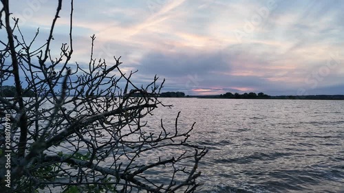 Slow Forward Camera Movement Along Windy Freshwater Lake Shore at Sunset