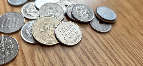 assorted group of japanese yen coins on a brown wood background