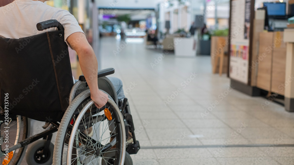 Obraz premium A Caucasian woman in a wheelchair shopping at a mall.