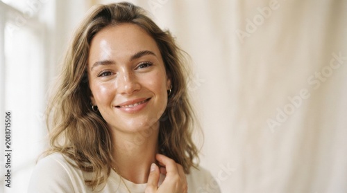 Smiling young woman portrait with natural light and neutral background for lifestyle headshot and profile image
