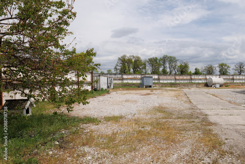 Empty industrial yard with gravel surface and storage tanks