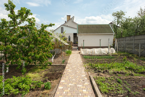 Rural house with vegetable garden and paved walkway