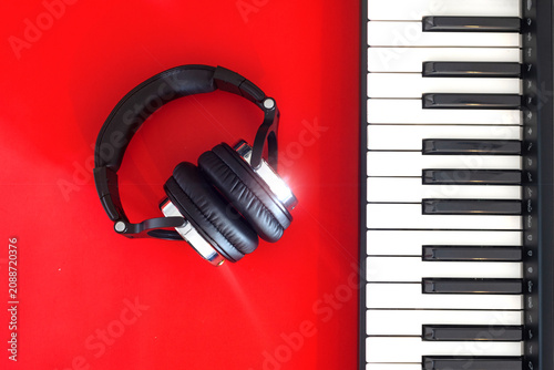 Fotografija Black and white headphones and black and white keys of digital piano