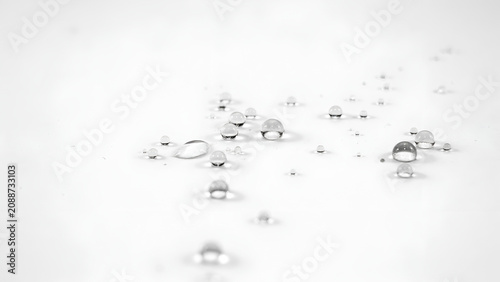Macro close-up of clear water droplets scattered on a white surface