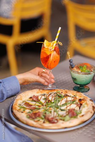 Friends toasting with cocktails and wine over pizza
People celebrating with drinks in Italian restaurant
Cheers with Aperol Spritz and wine during dinner