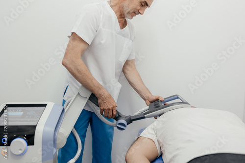 Fotografie Physiotherapist performing TECAR therapy, radiofrequency rehabilitation equipment