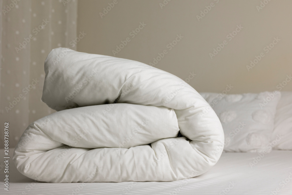 Obraz premium Soft White Duvet Folded on Bed in Cozy Bedroom Interior 