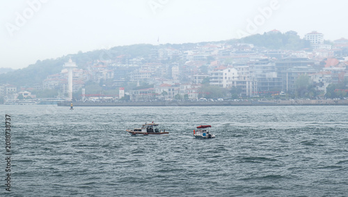 small fishing boats at sea. The Bosphorus strait. Istanbul, Turkey. The Uskudar coastline in the background.