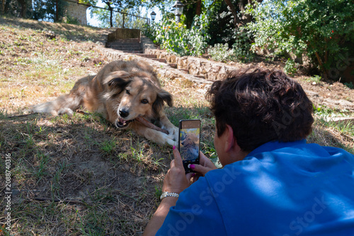 Woman Taking a Picture of Her Dog with Phone