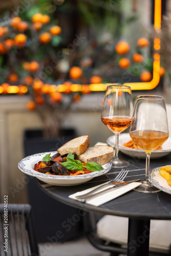 Restaurant table with gourmet dishes and wine
Elegant outdoor dining table in restaurant
Fine dining meal served on terrace with wine
