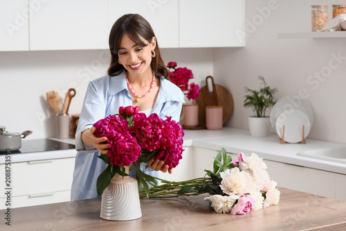 Young woman arranging pink ...