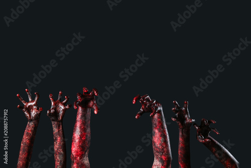 Foto Many hands of zombies on black background. Halloween celebration