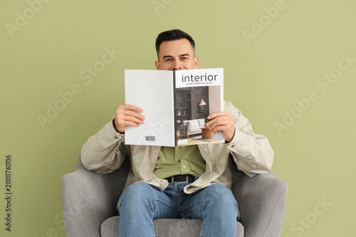 Handsome man reading magazi...