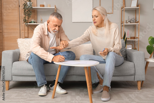 Mature couple signing divorce decree at home