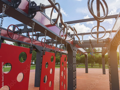 Outdoor obstacle course with hanging rings, monkey bars, suspended panels on modern fitness playground designed for OCR sport, ninja training, functional workout, endurance, strength, agility