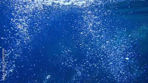 Sunbeams and bubbles underwater. Underwater slow motion bubbles moving to surface in turquoise crystal clear sea. air bubbles underwater bubbles coming up to the surface blue water ocean scenery. Pool