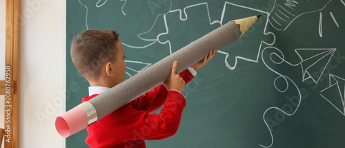 Boy holding oversized penci...