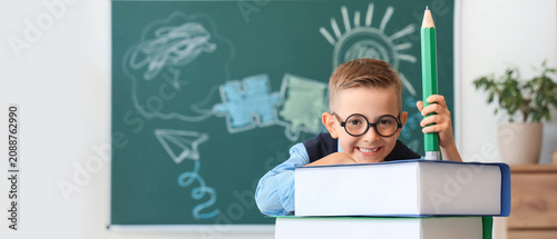 Smiling boy with glasses ho...
