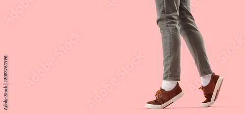 Bild auf Leinwand Person walking in brown sneakers on pink background