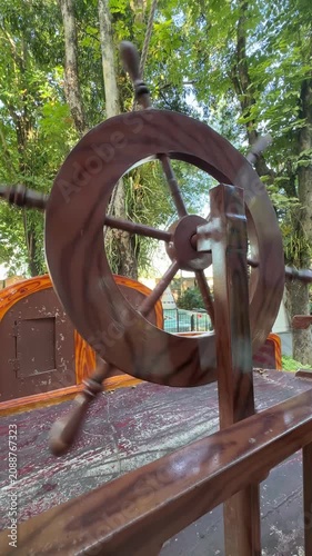 Operating a Wooden Ship Wheel on a Park Playground