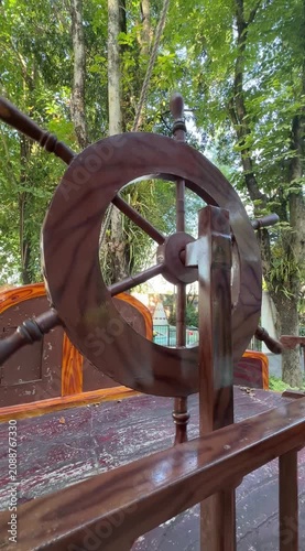 Operating a Wooden Ship Wheel on a Quiet Waterside Deck