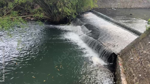 Observing A Small Waterfall Over a Concrete Spillway in a Quiet Canal