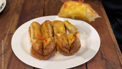 Preparing a Plate of Crispy Garlic Bread with Cheese in a Home Kitchen