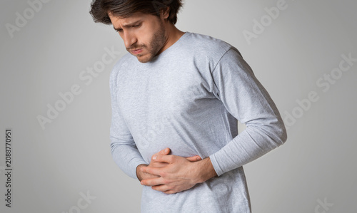 Fotografía Young man hands on stomach, having bad aches pain