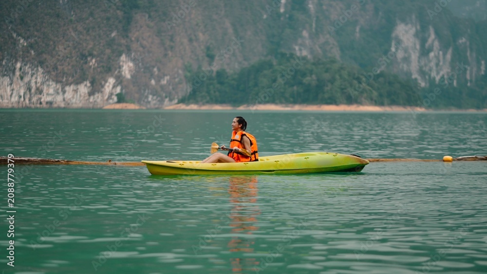 Fototapeta premium Woman kayaking on khao sok lake water, enjoying refreshing active travel vacation