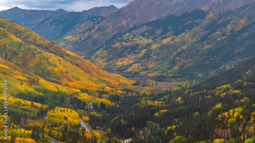 Obraz premium Aerial view of Colorado fall landscapes along Million Dollar Highway with views of mountainside fall foliage trees in San Juan Mountains during autumn season