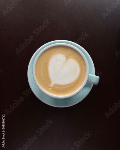 Overhead view of a latte coffee with heart shaped froth decoration