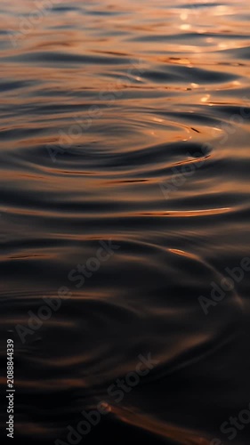 Sunset water surface ripple golden reflection calm wave soft light abstract nature peaceful mood minimal background tranquil seascape warm serene