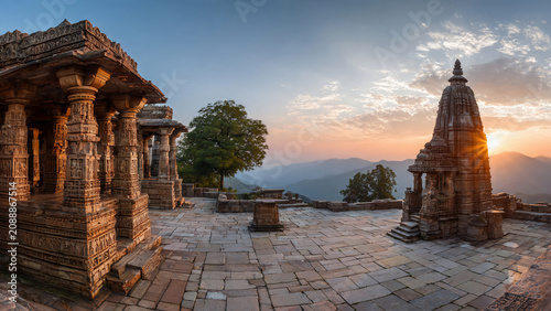 Ancient intricately carved stone temple ruins at sunrise with sunburst over misty mountains, perfect for travel, culture and historical exploration