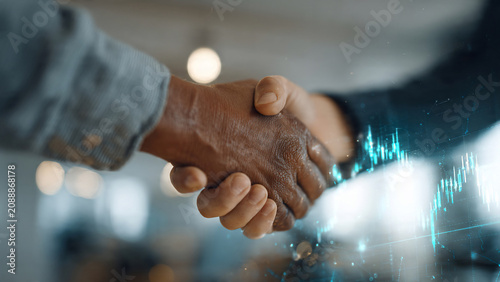 Close-up of diverse hands shaking with glowing financial graph overlay, representing partnership and growth, ideal for business deals, financial services and investment concepts