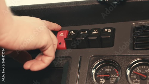 Truck driver pressing hazard warning light button