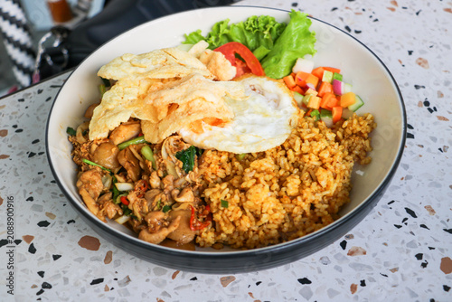 фотографія Indonesian signature dish Nasi Goreng accompanied by fresh pickles egg and crunc