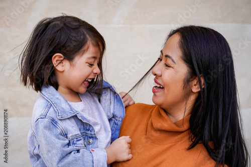 Happy asian mother having fun with her daughter child - Family relationship and love concept - Focus on mom face