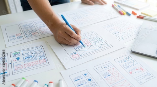 Obraz na płótnie Professional design studio workspace featuring website wireframe drawings and development prototypes.