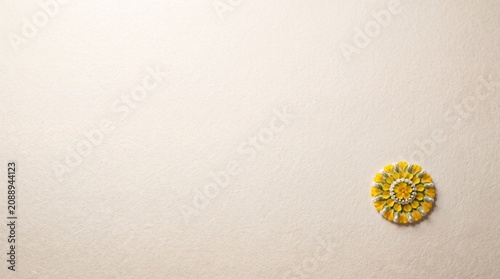 Minimalist floral Pookalam design made of yellow Mukkutti and white Thumba flowers placed on a textured beige background with ample copy space for Onam festival greetings.
