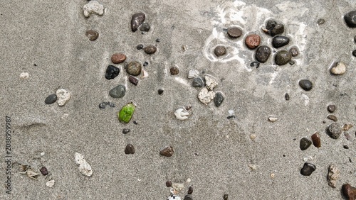 Wet Sand with Pebbles Background with Beach Texture and Ocean Shoreline