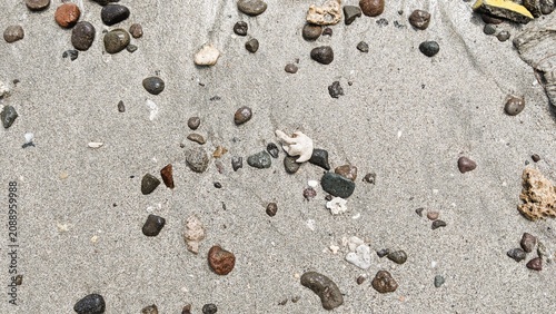 Wet Sand with Pebbles Background with Beach Texture, Ocean Shoreline, Coastal Nature Close Up