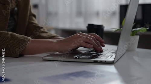 Person Using Laptop Computer for Work or Study in Modern Office Setting