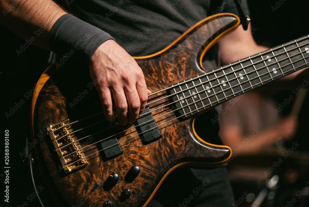 Obraz premium ライブ演奏でベースギターを弾く音楽家の手元クローズアップ写真