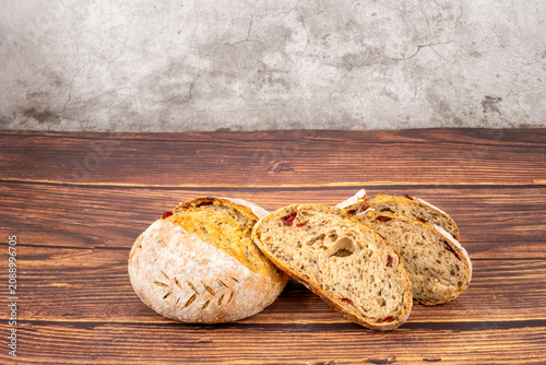 Freshly baked sourdough bread loaf on the wooden and white background with full depth of field. Artisanal or healthy food concept
