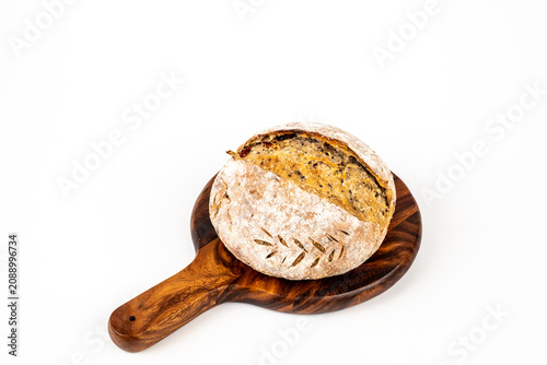 Freshly baked sourdough bread loaf on the board and white background with full depth of field. Artisanal or healthy food concept