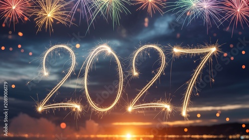 Sparkling 2027 New Year celebration scene with golden sparkler numerals vibrant multi colored fireworks glowing dusk sky and coastal city bokeh lights for festive greetings event promotions